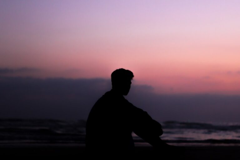 silhoutte of man sitting on ground