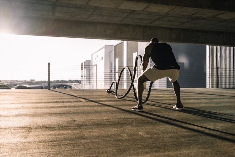 man in black t-shirt and white shorts walking on brown wooden floor