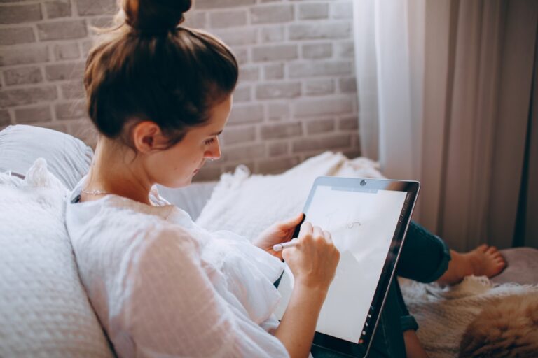 woman in white shirt holding white tablet computer